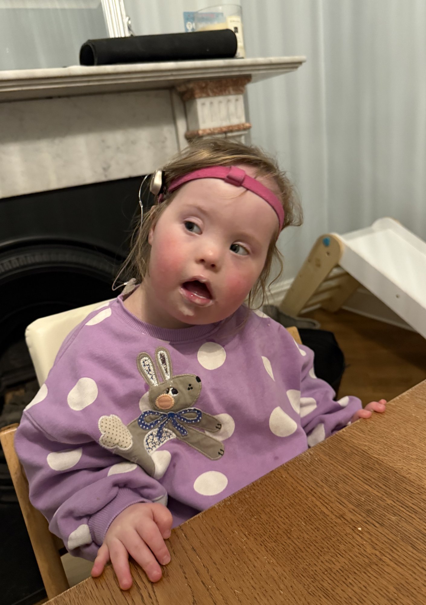 Toddler with Down syndrome using fingers and hands during feeding, building fine motor skills, coordination and hand strength