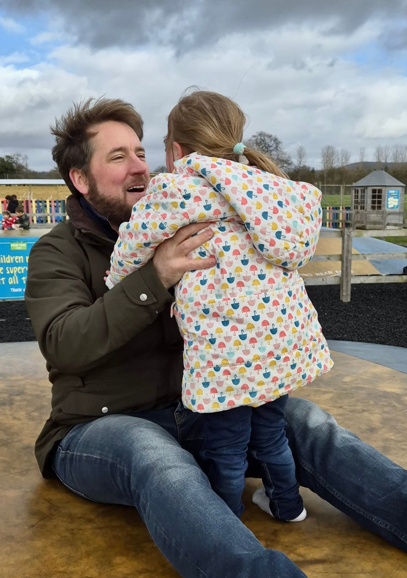 Father lifting child with Down syndrome during play, supporting overall development, motor skills and emotional well being