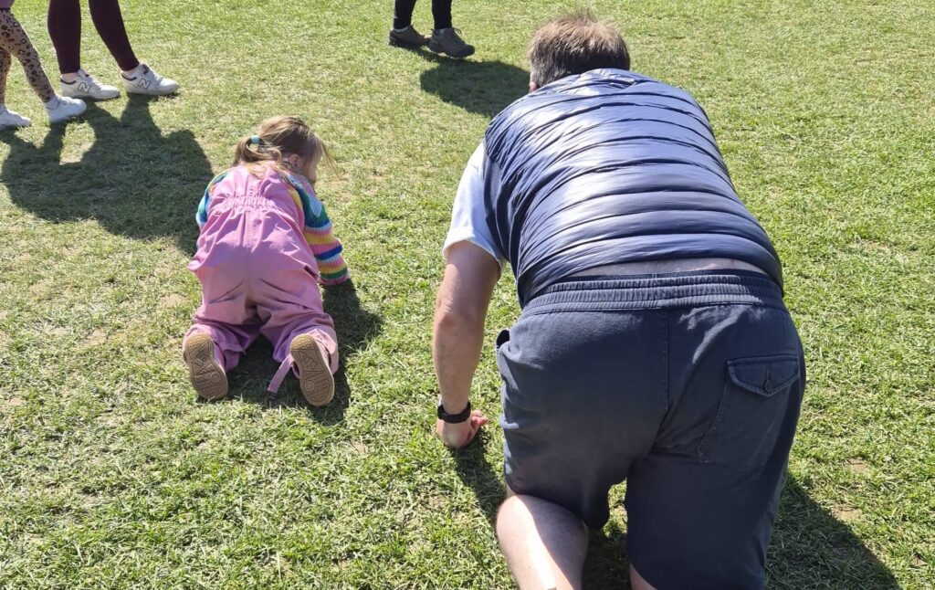 down syndrome toddler and her father crawling, practising her core so she can gain enough muscle strenght to later walk